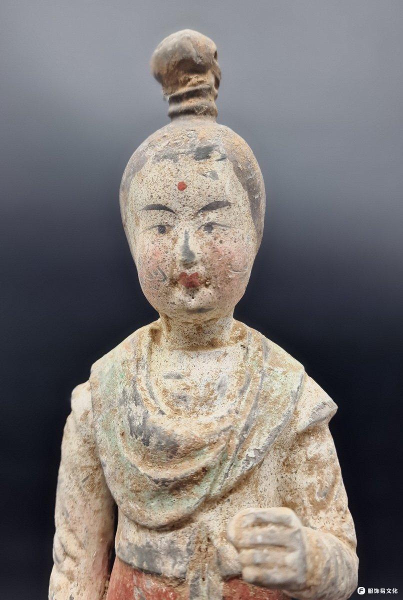宫女 捧着 水壶。她的头发扎成了高高的发髻。她穿着一条红色长裙、一件短袖上衣和一条披肩。 这种时尚始于 ......